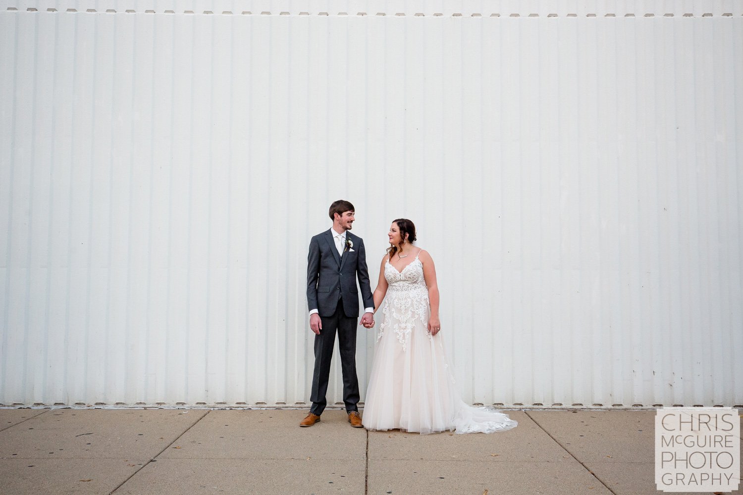 Bride and groom with white wall in Peoria IL