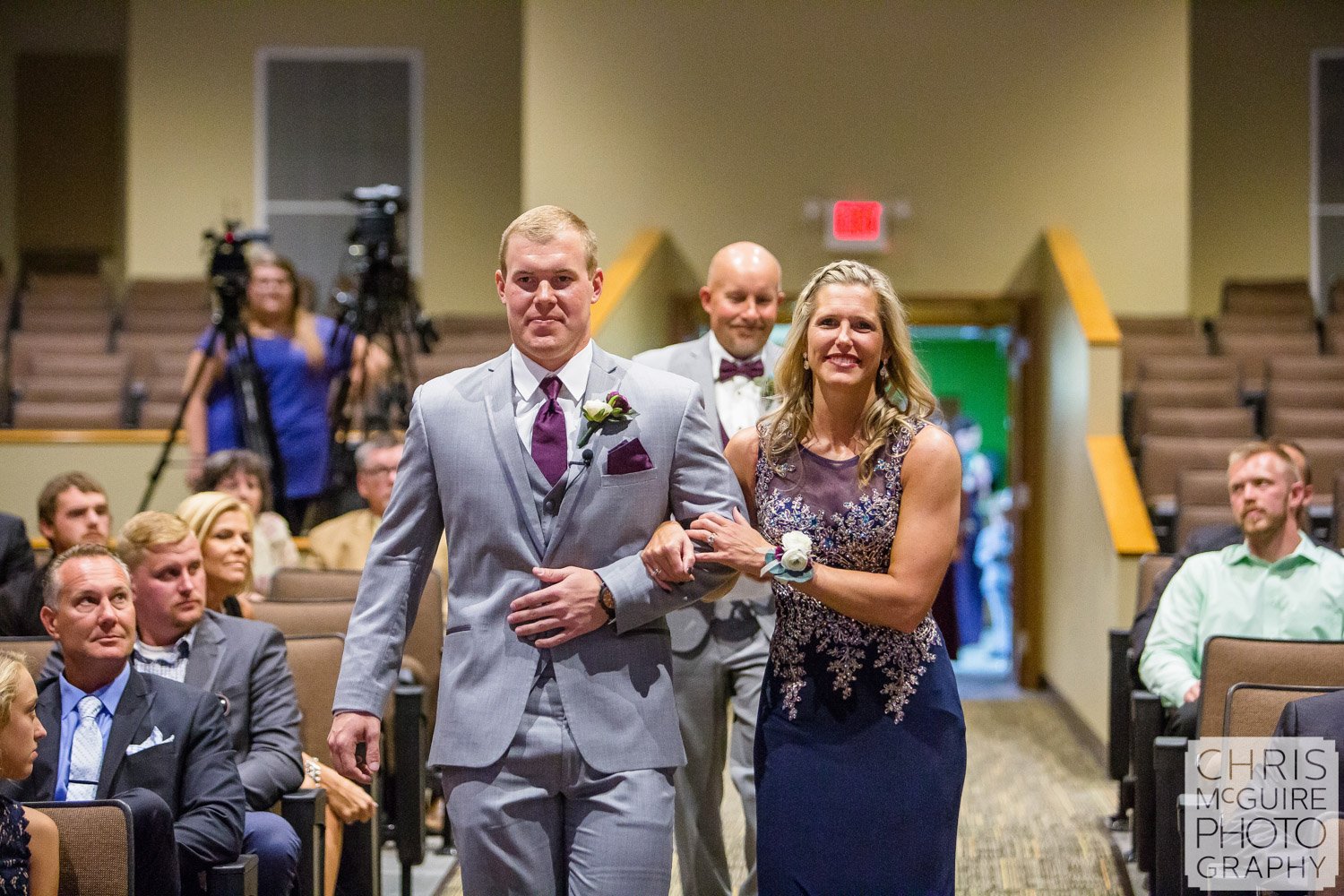 groom walking down aisle with parents