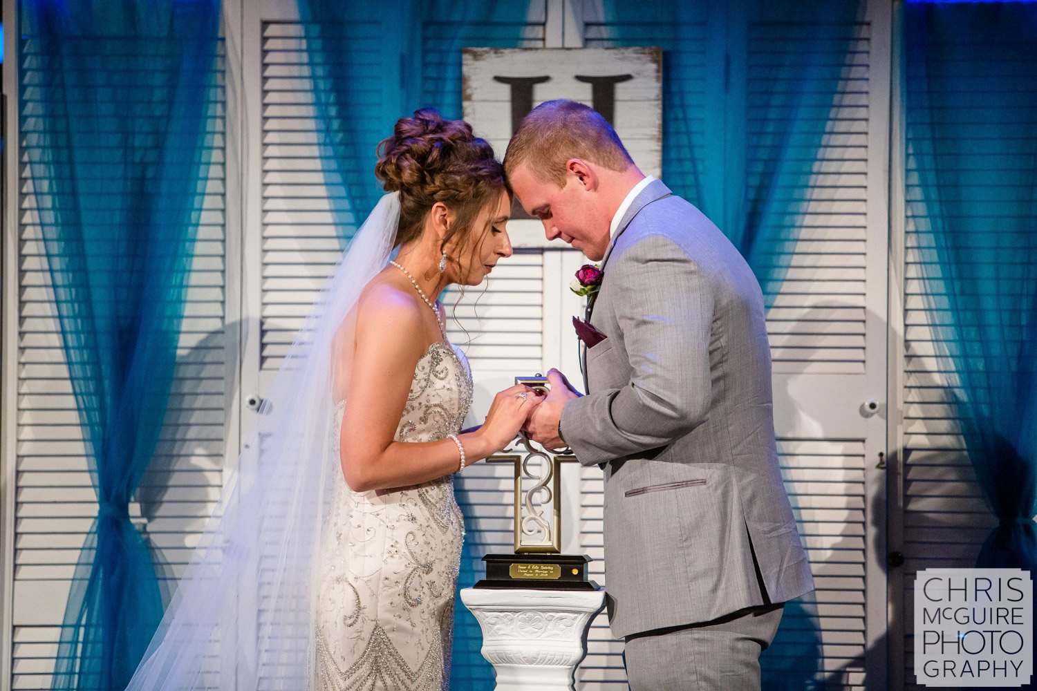 bride and groom pray together at Harvest Bible Chapel Peoria IL Wedding