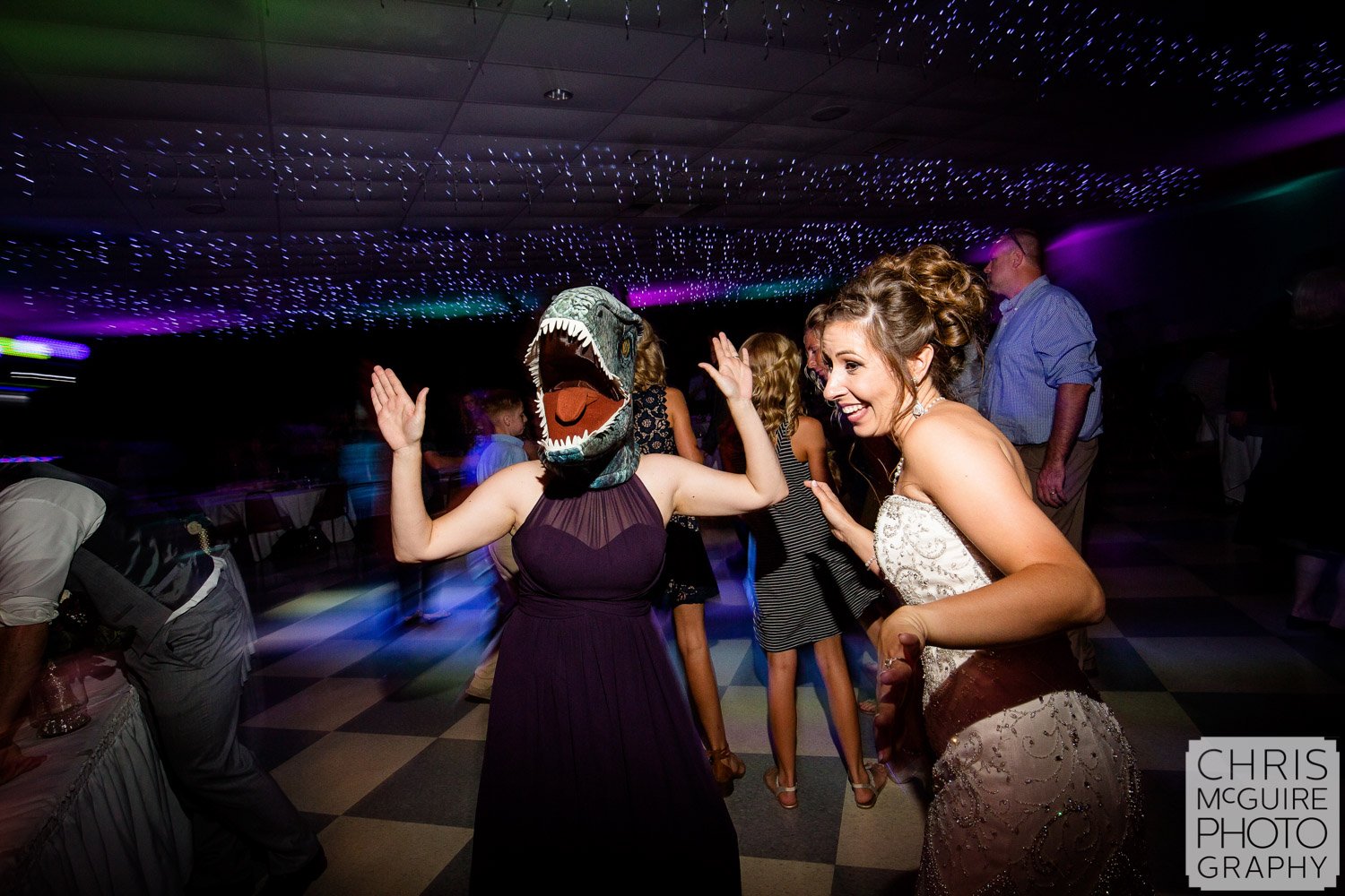 dinosaur mask and bride dancing at wedding reception