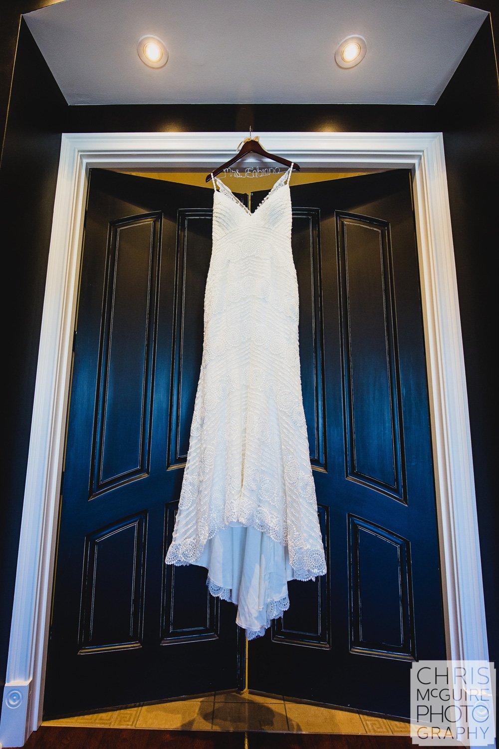 wedding dress hanging on black door