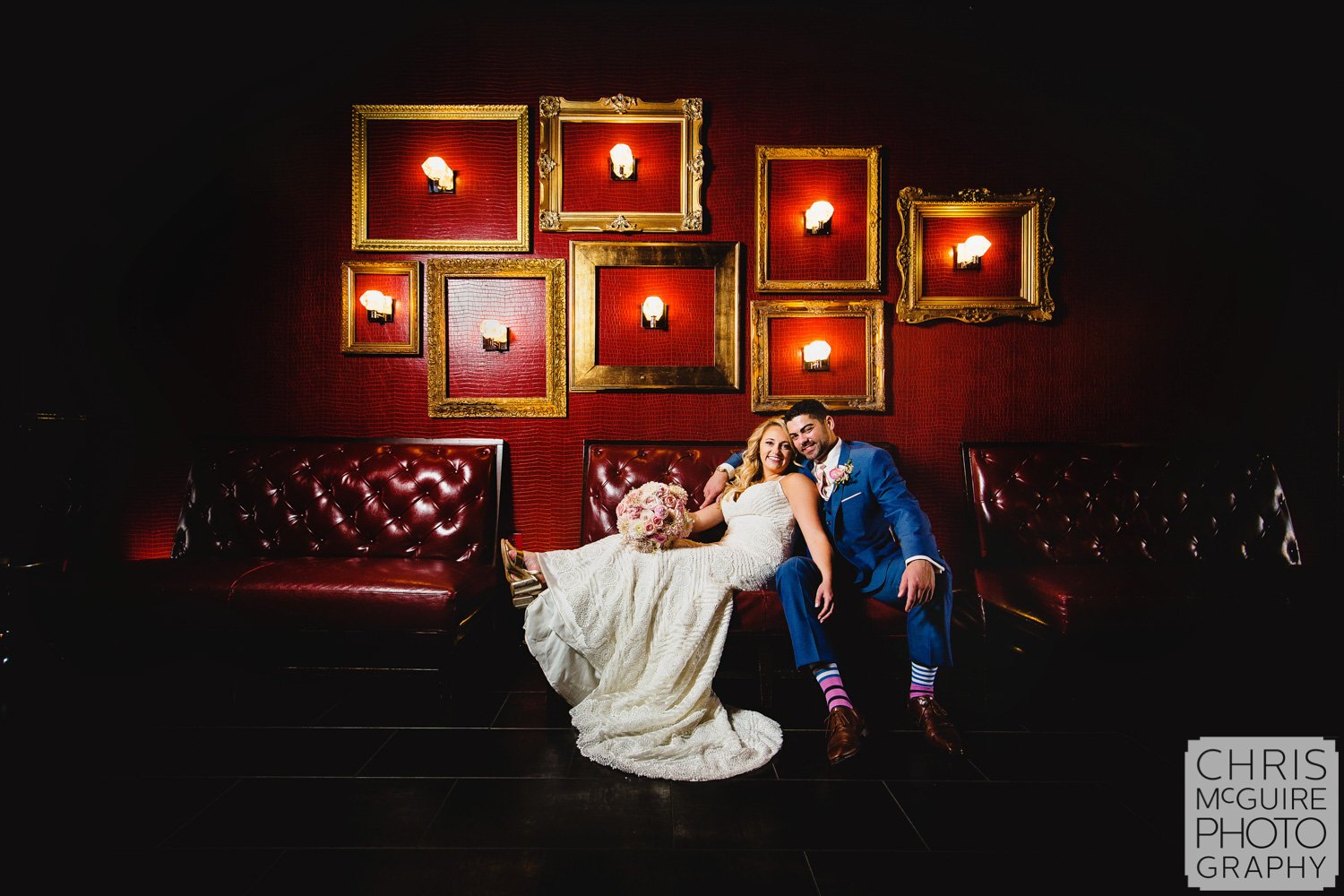 bride and groom with red wall