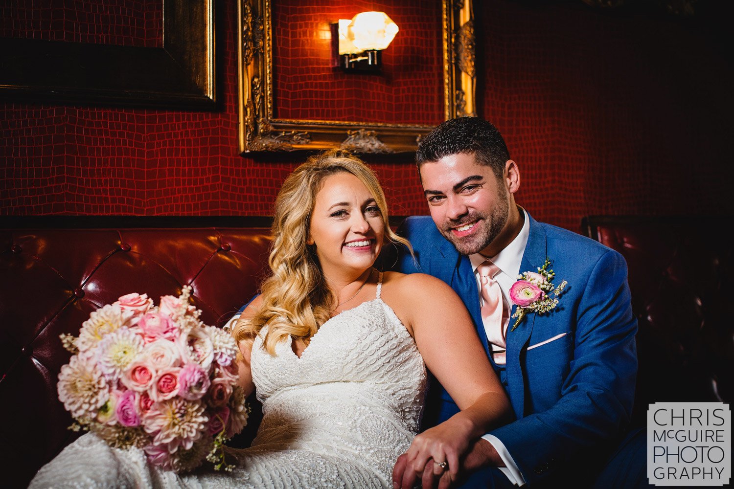 bride and groom with red wall