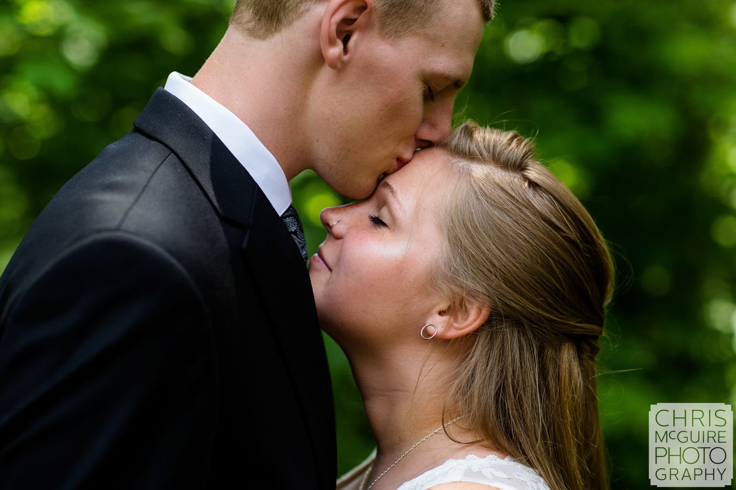 groom kissing bride's forehead