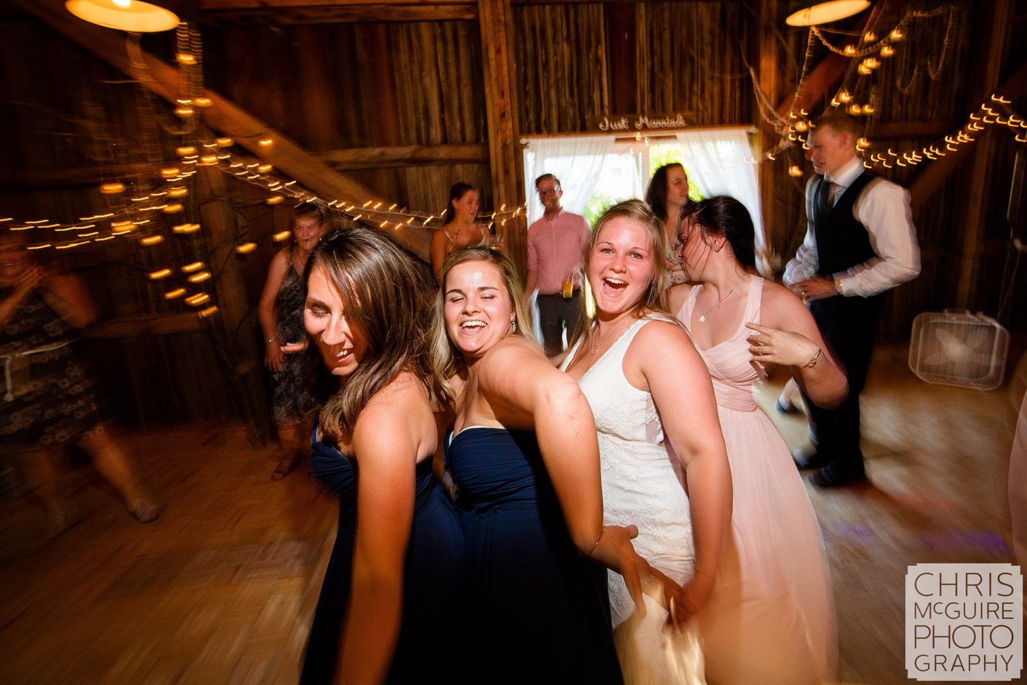 bride dancing with friends in barn