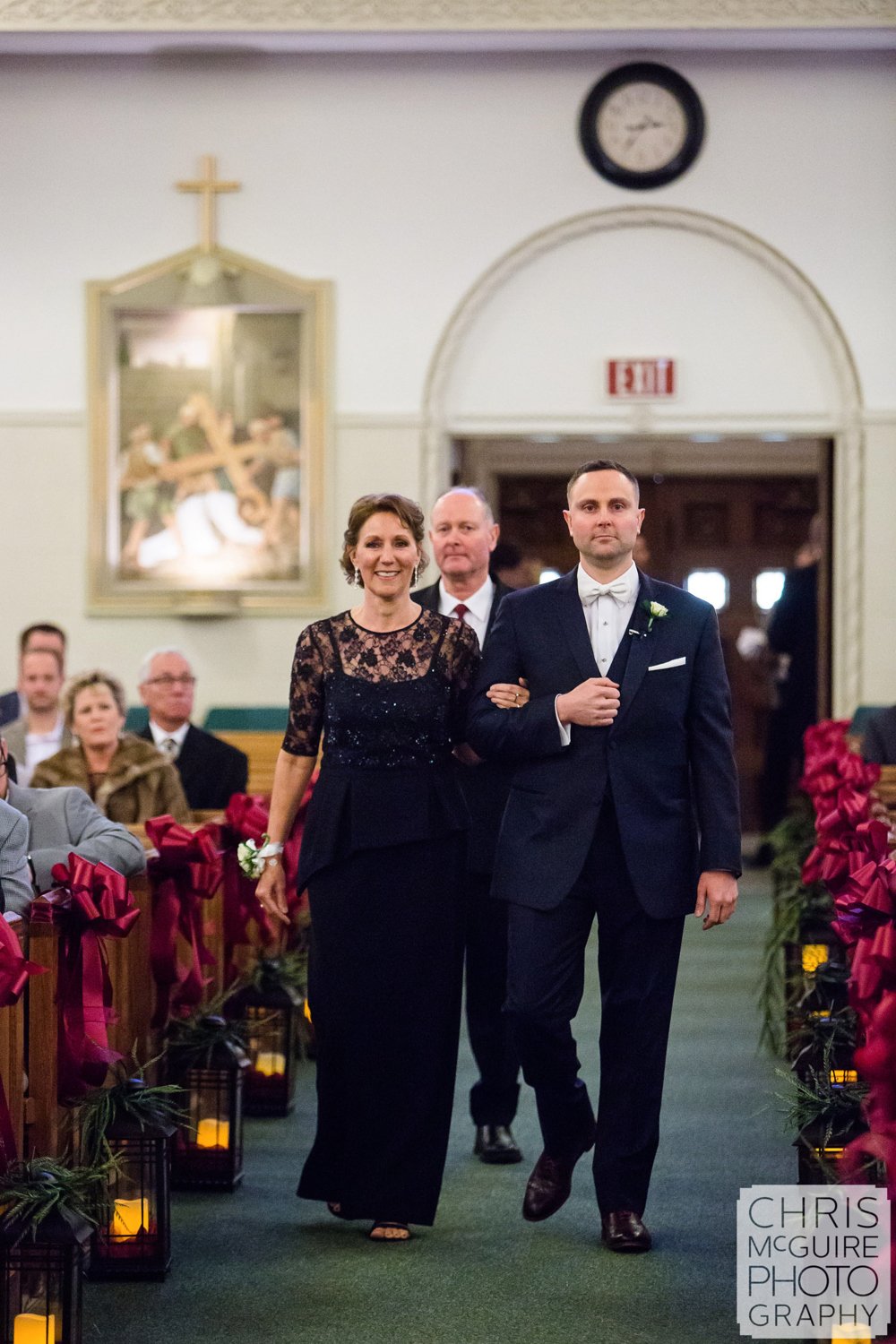 groom walking down aisle with parents