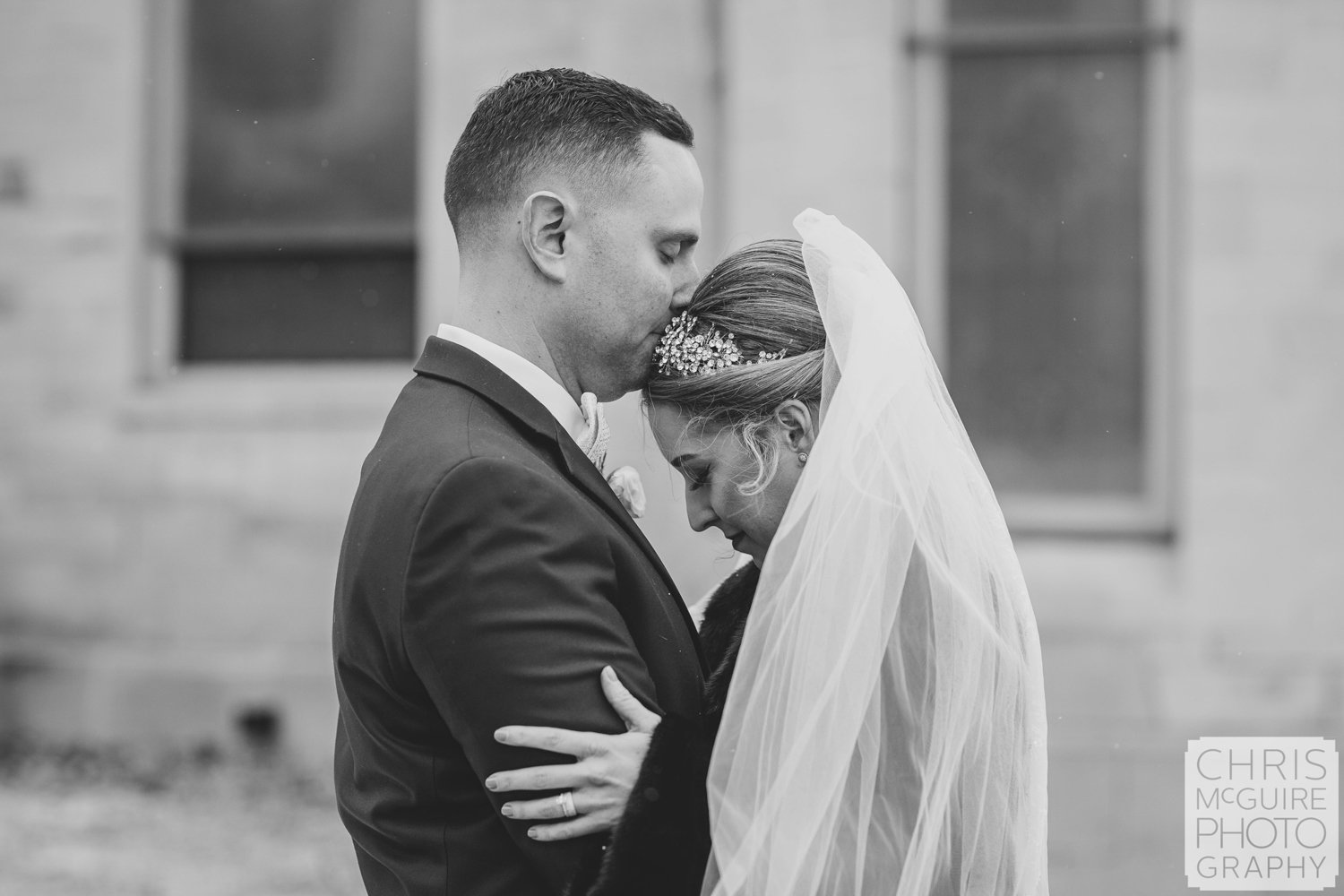 groom kissing brides head