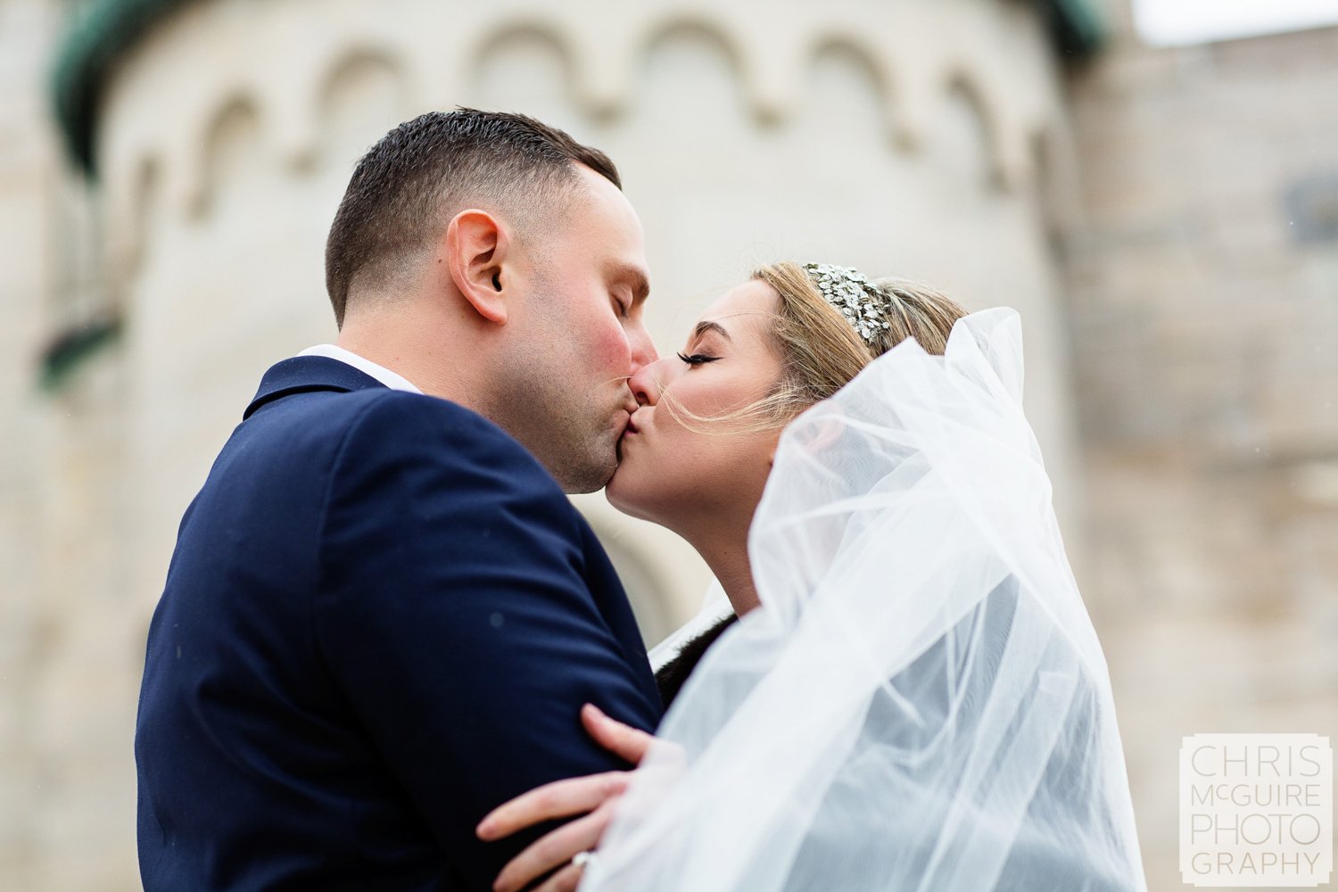 bride groom kissing in front of church
