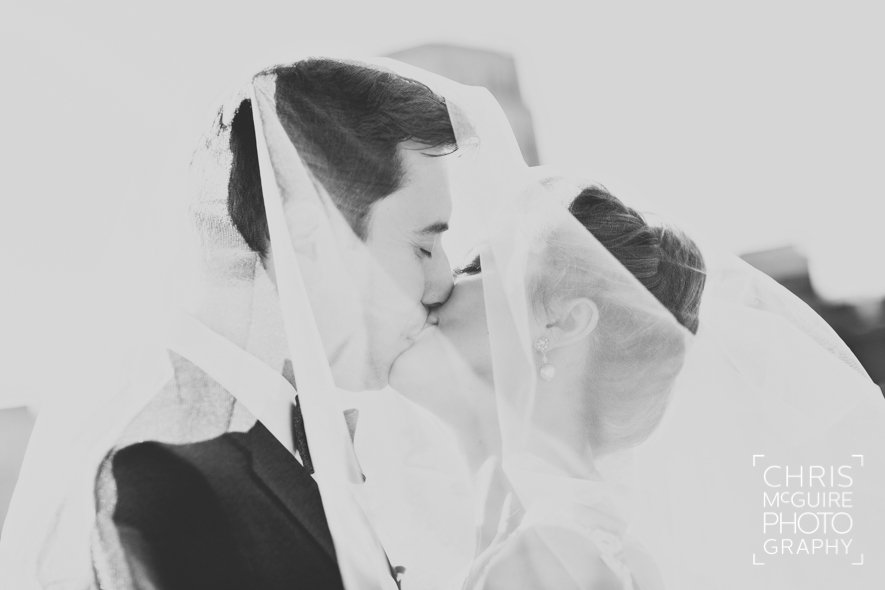 bride groom kissing under veil