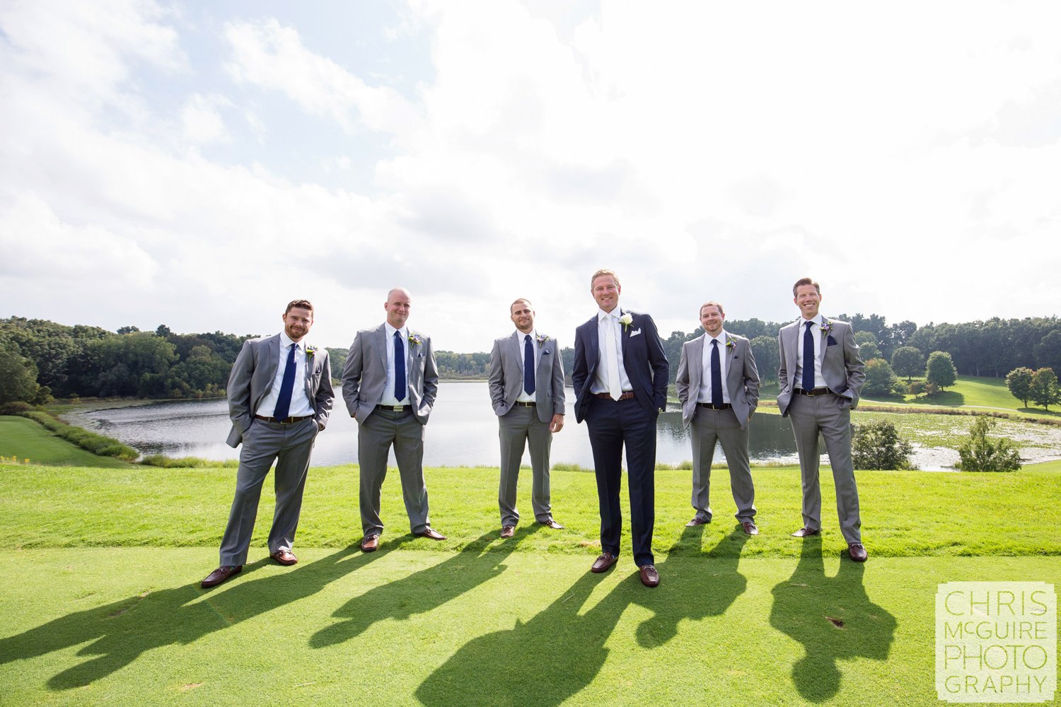 groom and groomsmen on golf course with lake