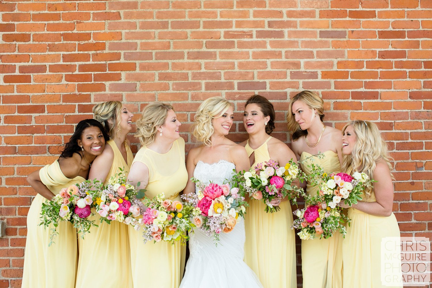 bride bridesmaids with bouquets brick wall