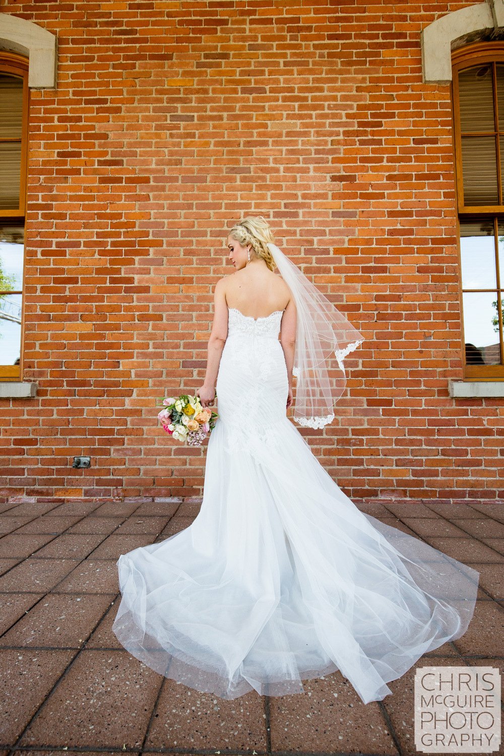 bride back of dress brick wall