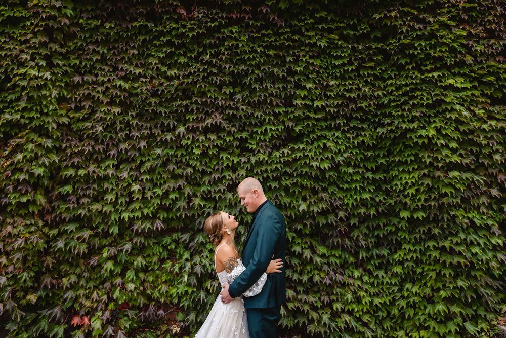 Bride and groom with ivy wall