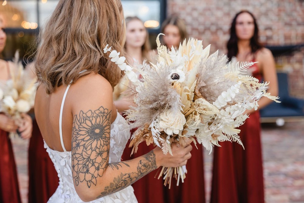 Bride with tatoo holding bouquet