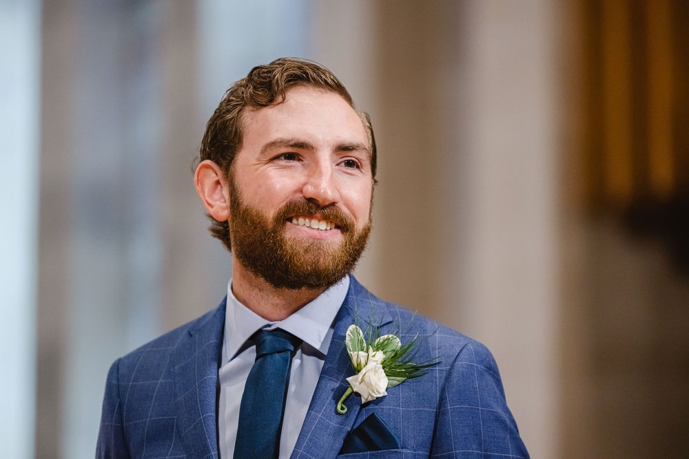 Groom smiles at bride