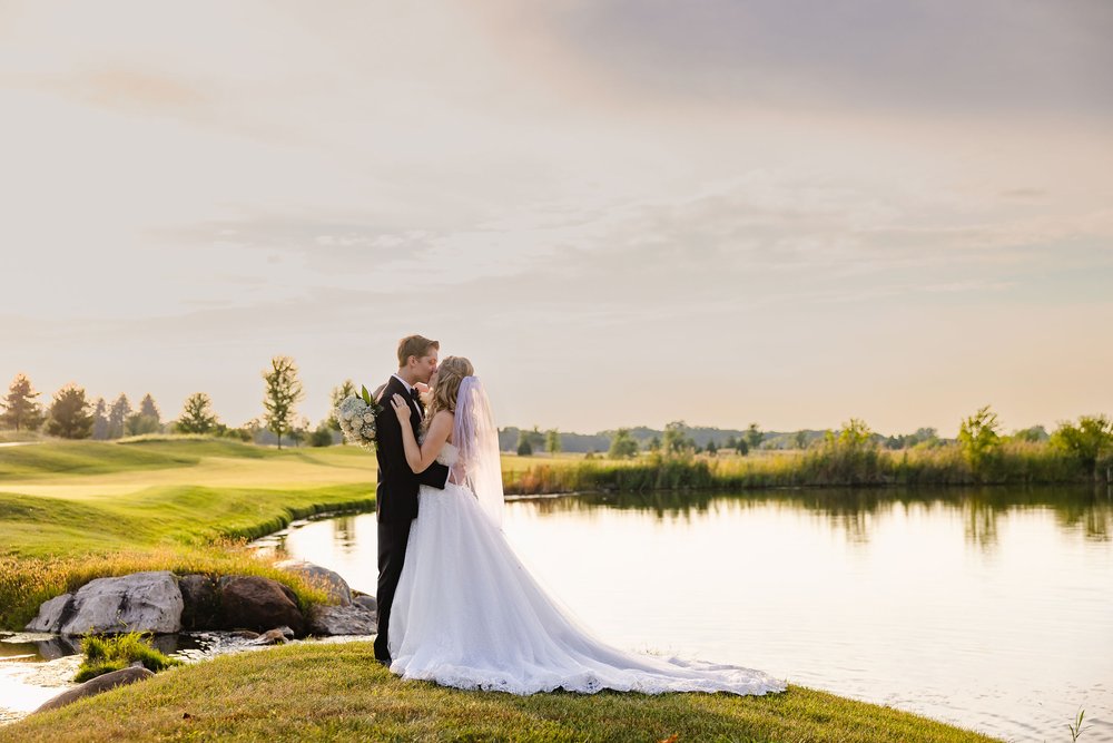 Bride and groom kiss at sunset