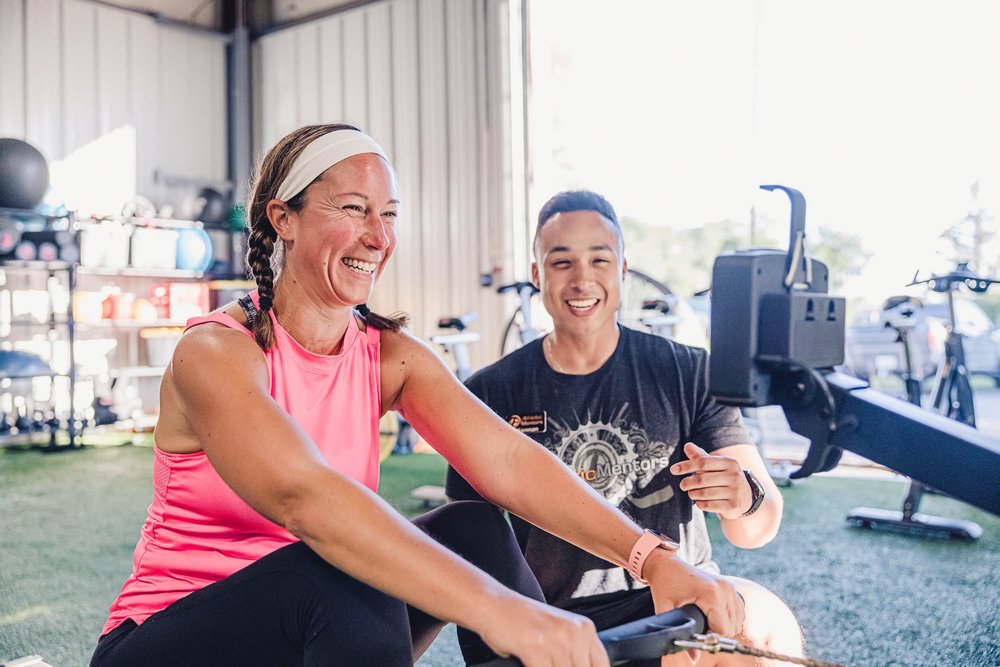 Woman on rowing machine with trainer