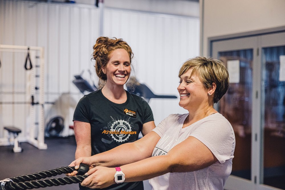 Woman at gym with athletic coach