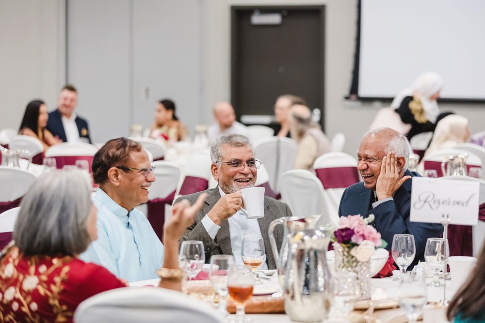 Man laughs at wedding reception