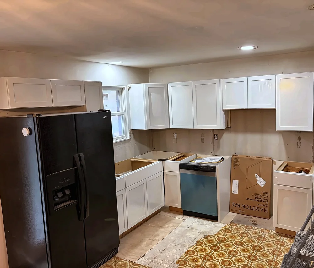White shaker cabinets, a tall pantry cabinet and a dishwasher going in before countertops and flooring