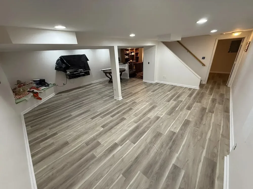 Finished basement with LVP flooring and recessed lighting