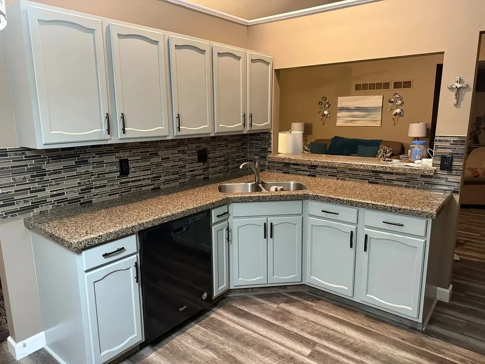 Remodeled kitchen with light cabinets, granite countertops and tiled backsplash