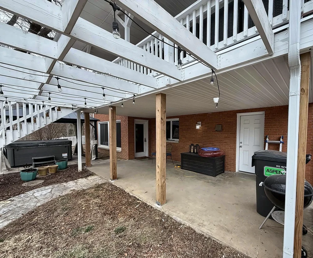 Finished covered basement patio with a new white vinyl soffit ceiling under the deck and new 6x6 wood support posts