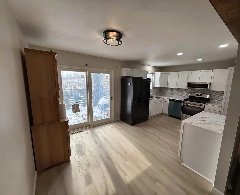 Open kitchen and dining area with a new peninsula, white cabinets, stainless appliances and light wood-look LVP flooring