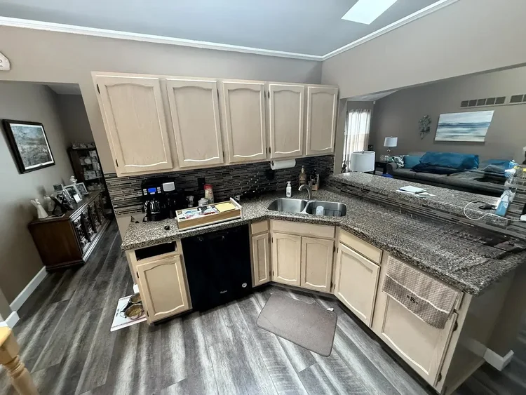 Kitchen with wooden cabinets, granite countertops, double sink, and appliances