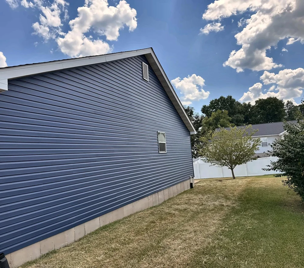 Garage-side gable wall covered in new Midnight Blue vinyl siding