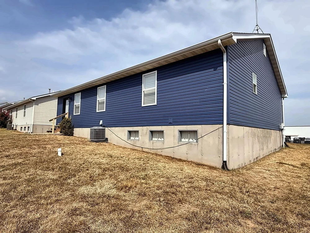 Rear corner of a ranch home in Midnight Blue vinyl siding with white window trim