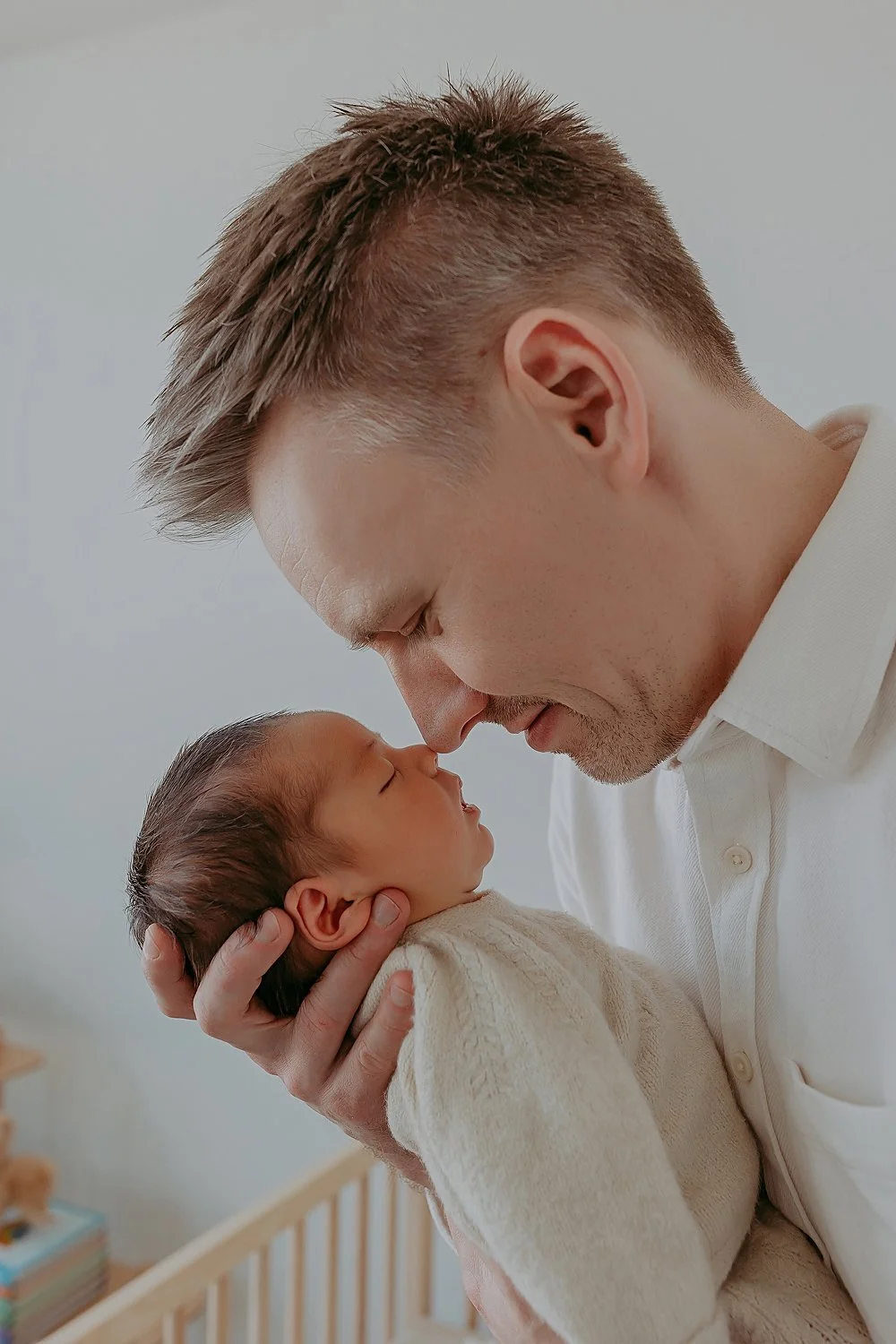 Father and newborn baby pose