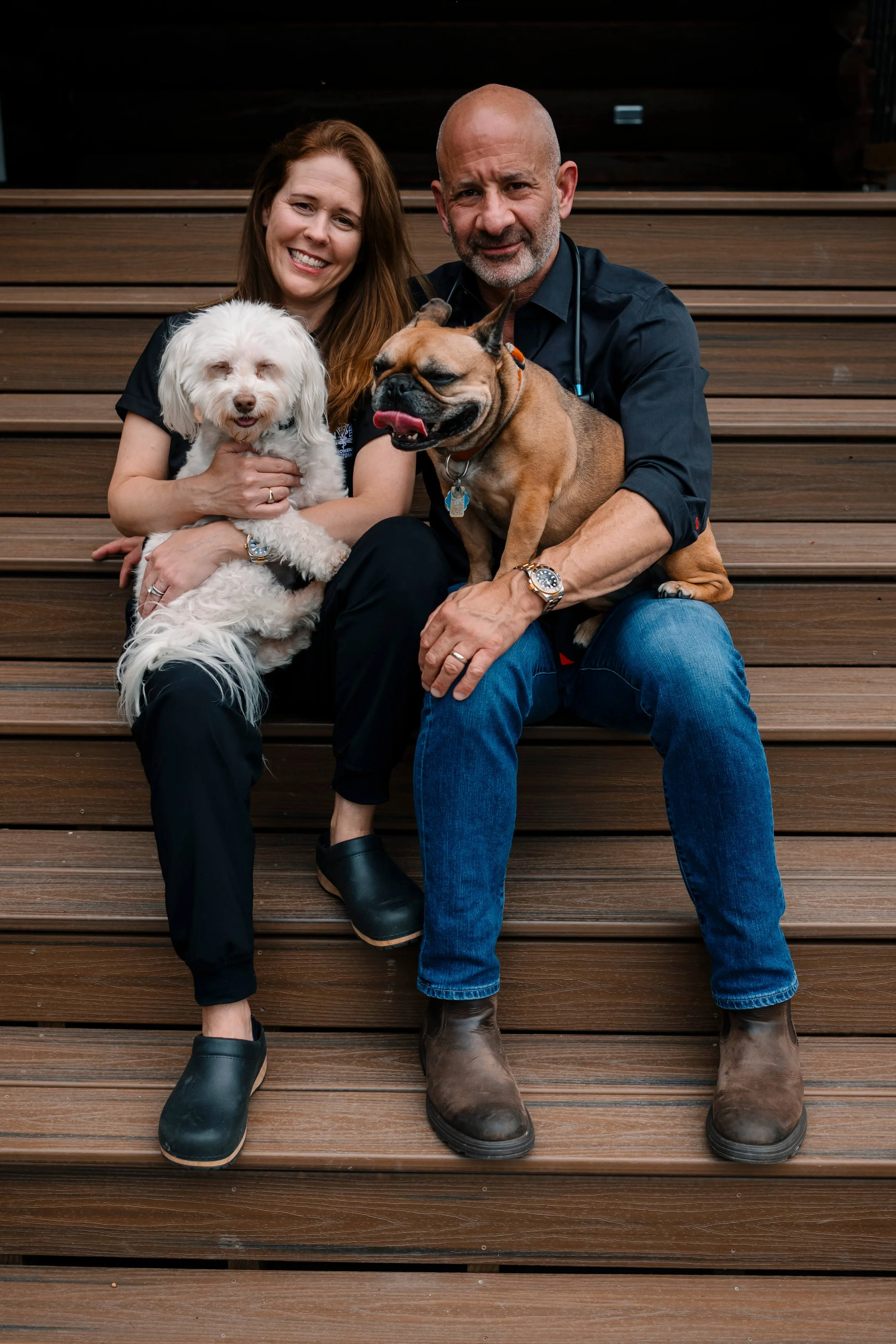 Dr. Hess and Leslie sitting on steps with dogs at Narrowsburg Veterinary office