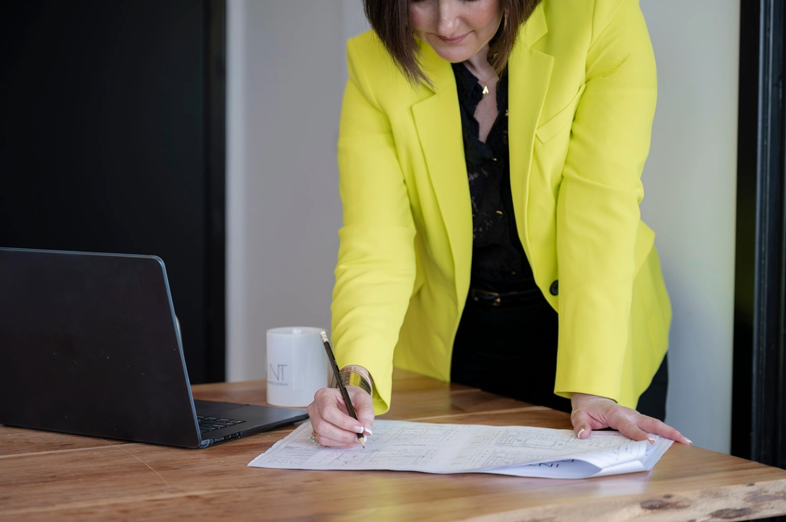 Alexis Solomon, Principal Designer and Founder of MINT Freshly Inspired Design in Victoria, BC, reviewing and marking up design plans at a desk.
