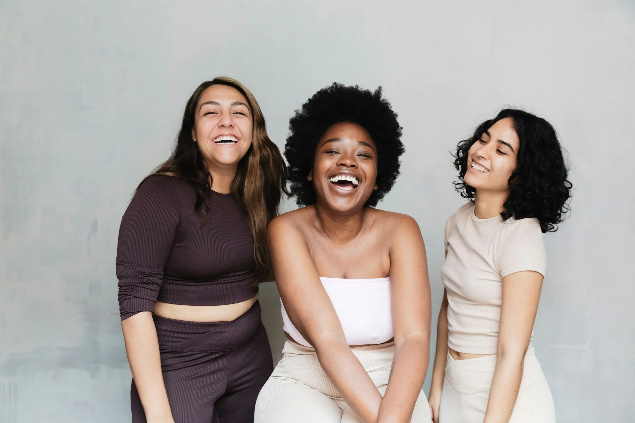 Three women smiling with grey background | Early Signs of Perimenopause | Scarlet Oak Wellness