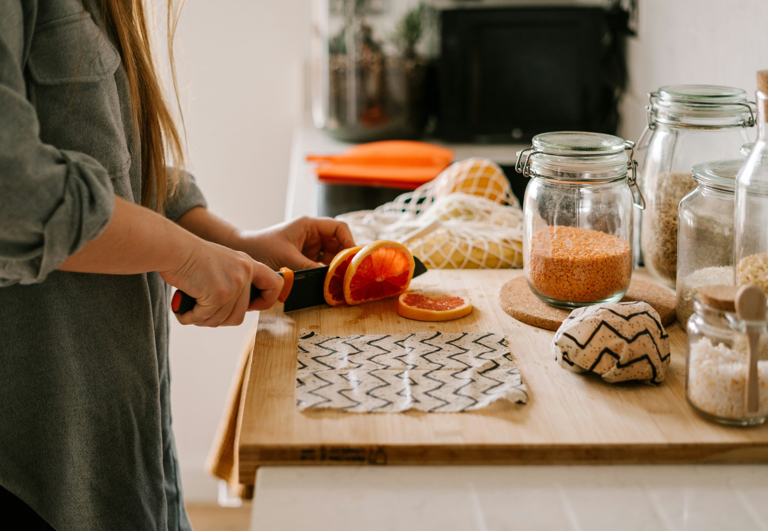 Women cutting an orange on cutting board | Reducing Microplastic Exposure