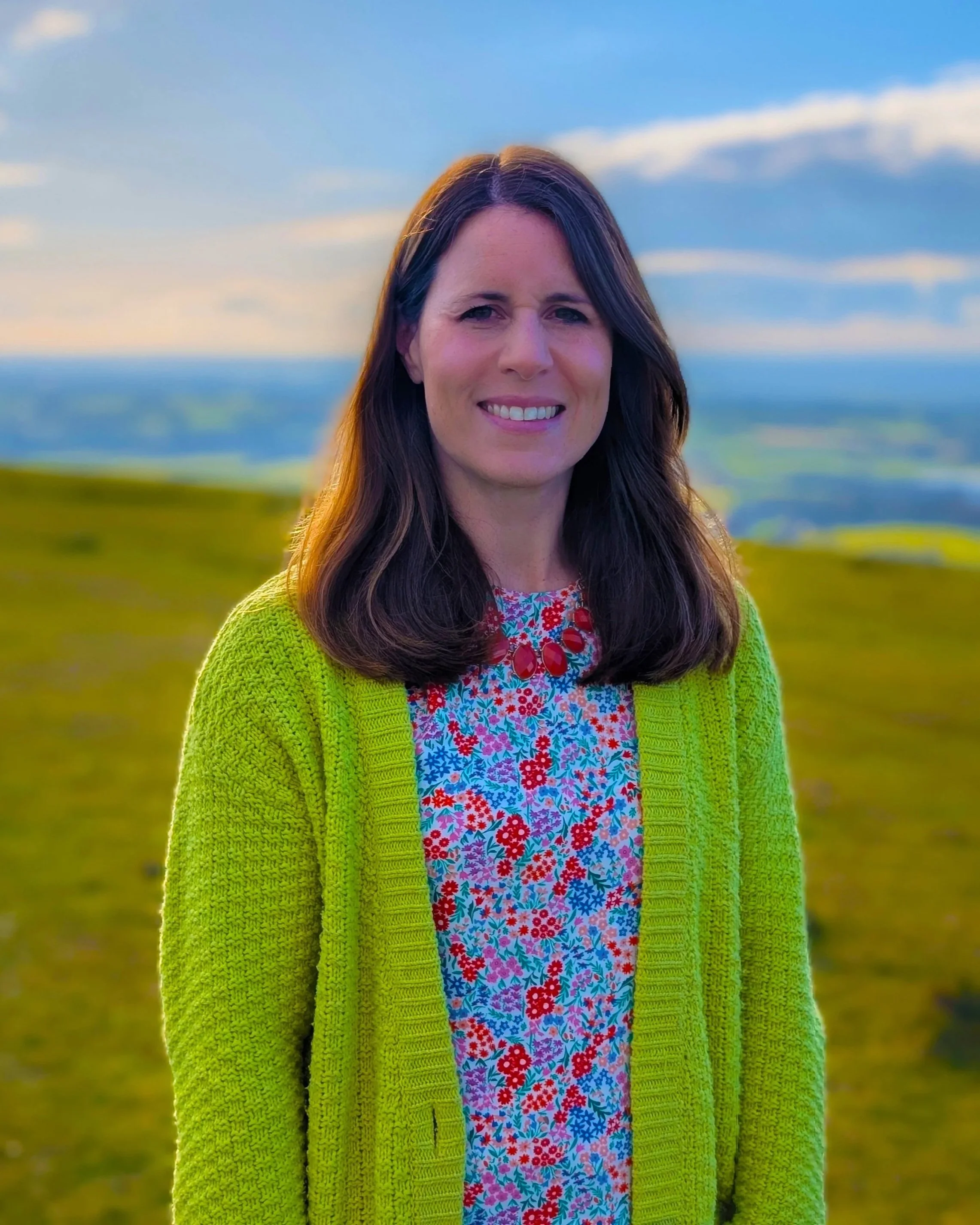 Emily, a freelance graphic designer, wearing a purple top with a beige backdrop.