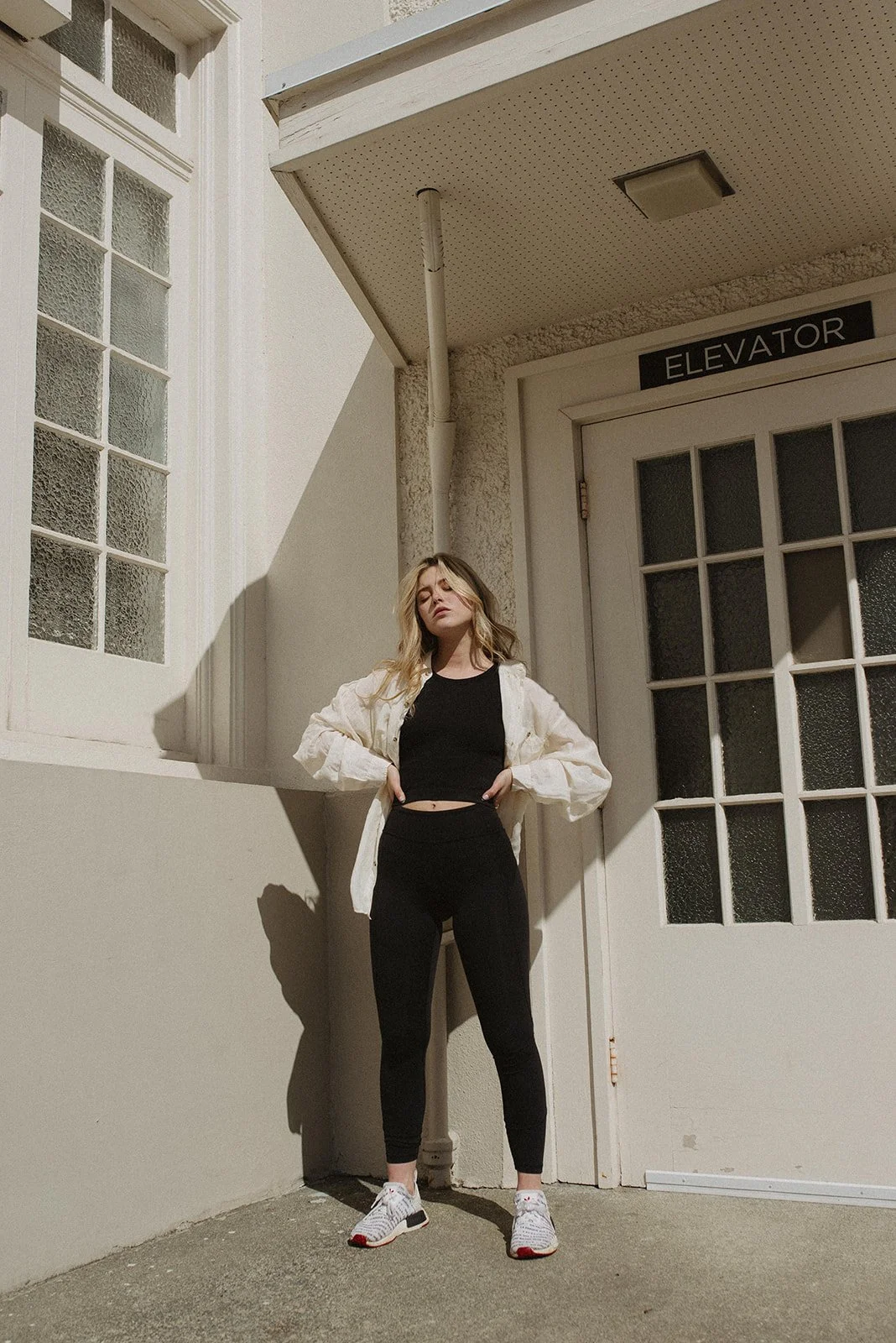 Image of a beautiful woman in front of a building in the sun in Victoria, BC