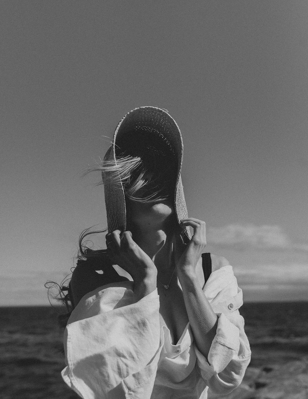 Black and white portrait of a woman by the ocean