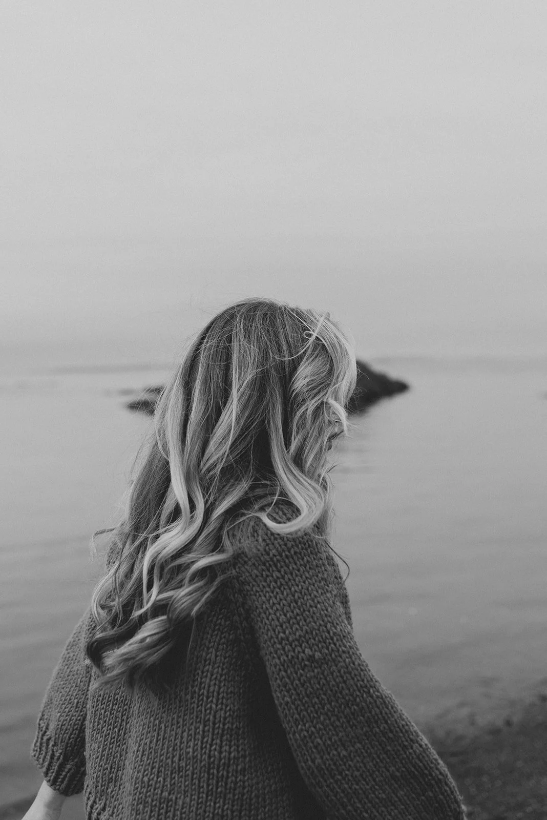 Black and white portrait of a woman with beautiful hair by the ocean in Victoria, BC
