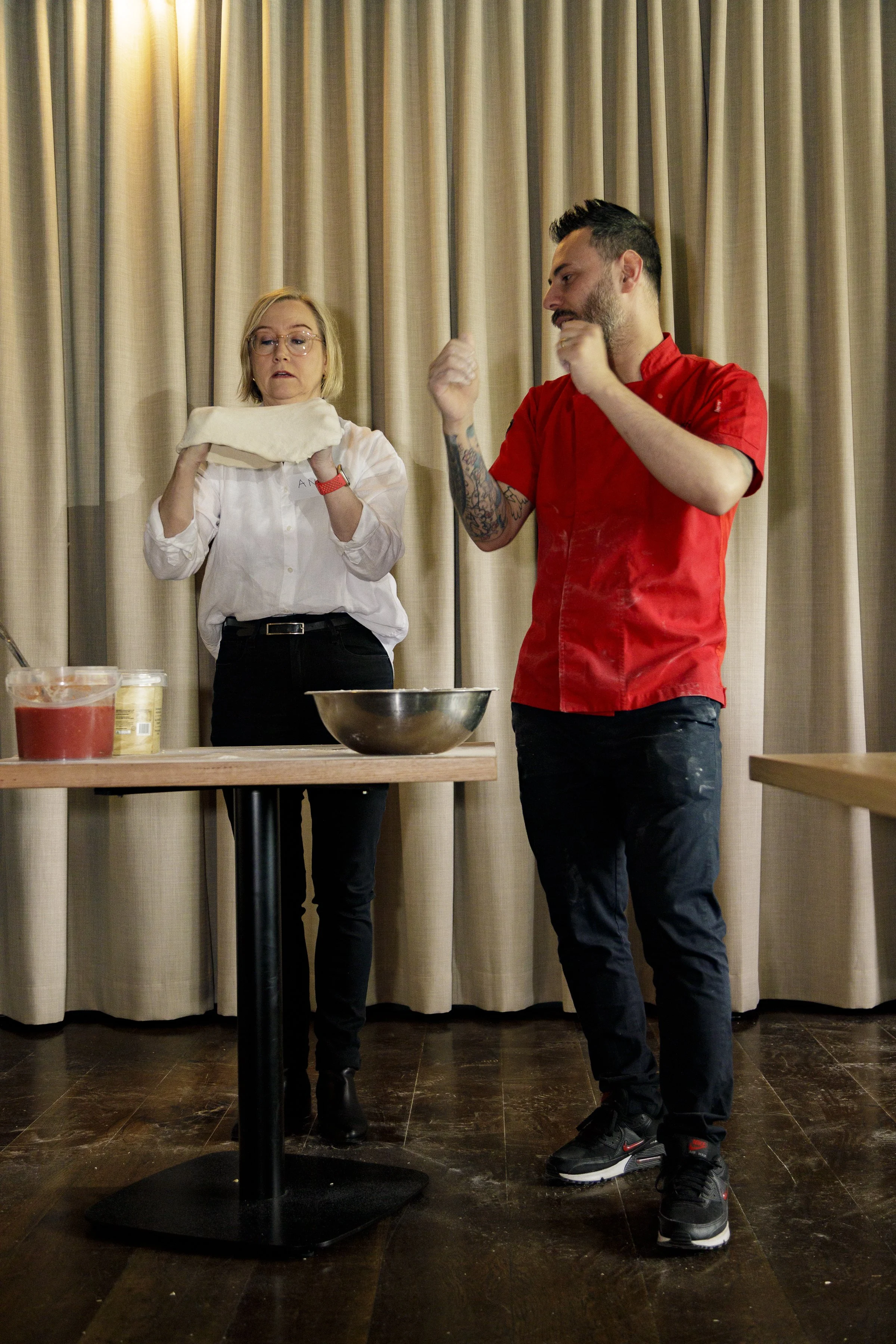 Francesco is showing a student of his pizza masterclass how to stretch out the pizza dough
