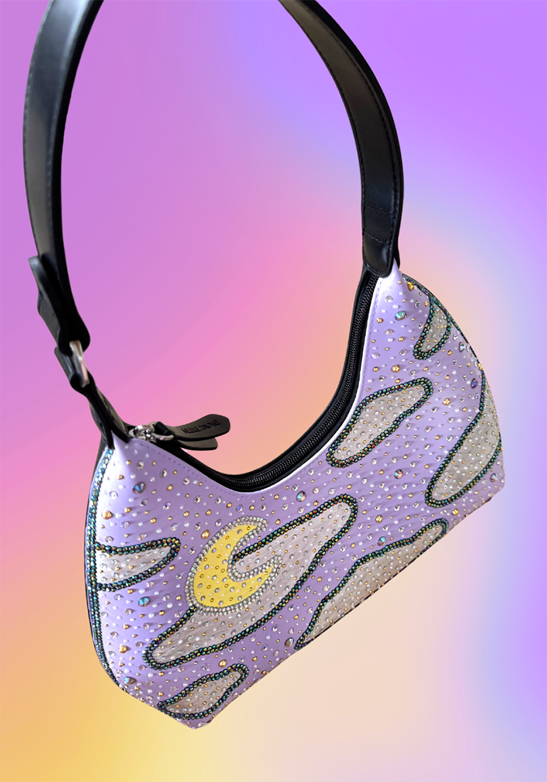 Hand-painted vegan leather handbag in lavender and black with an iridescent night sky, crescent moon design, and rhinestone details, called the Moon Magic Handbag.
