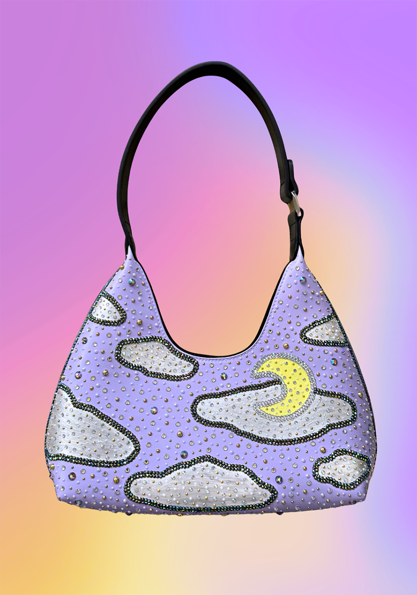 Hand-painted vegan leather handbag in lavender and black with an iridescent night sky, crescent moon design, and rhinestone details, called the Moon Magic Handbag.