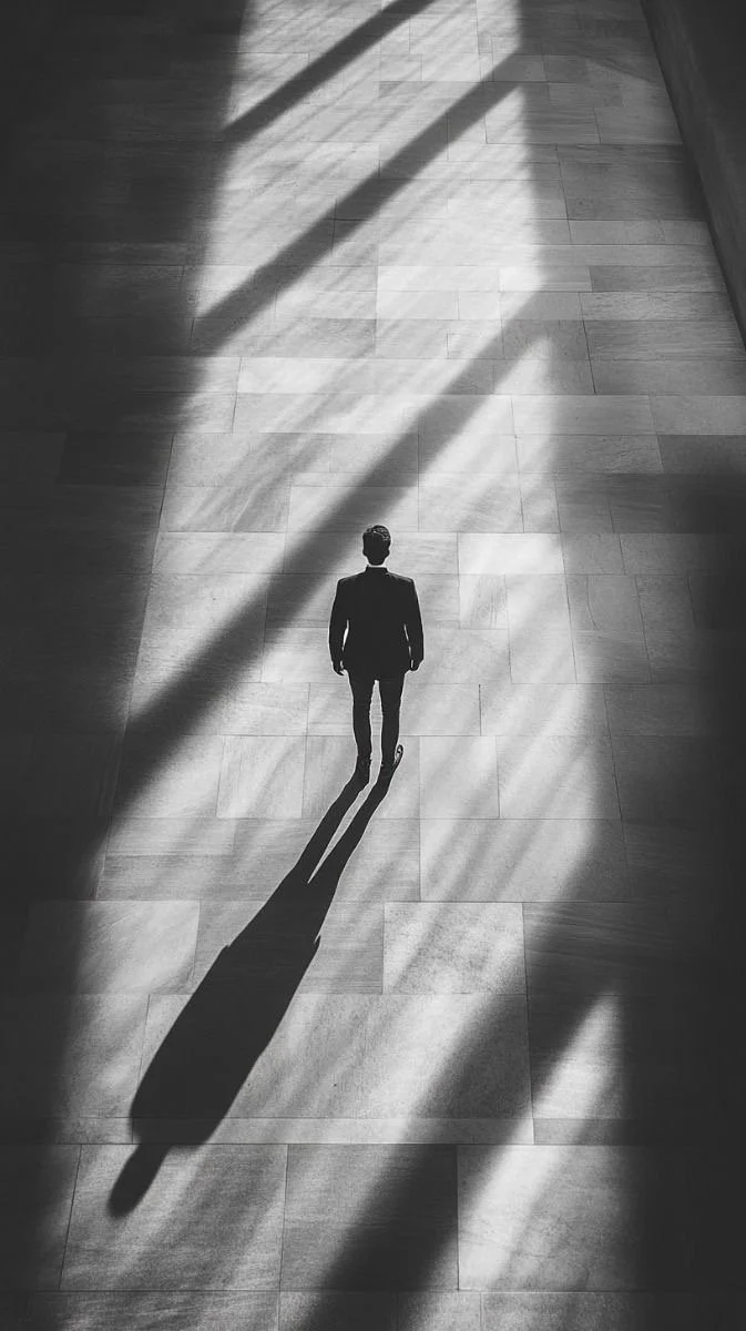 A man standing tall in a shadowy building serving as visual and tonal inspiration for the project