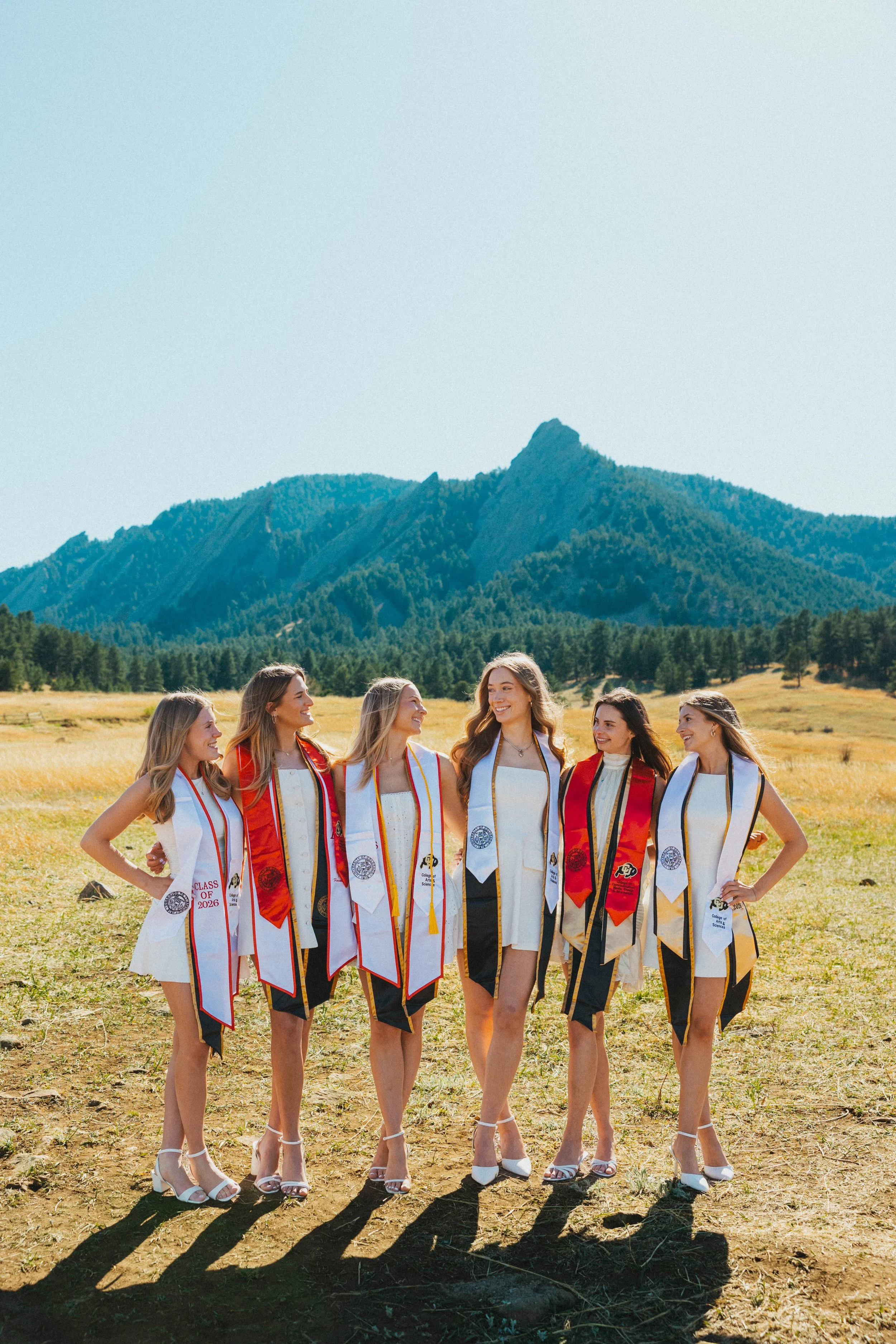 College graduates smiling together at Chautauqua Park