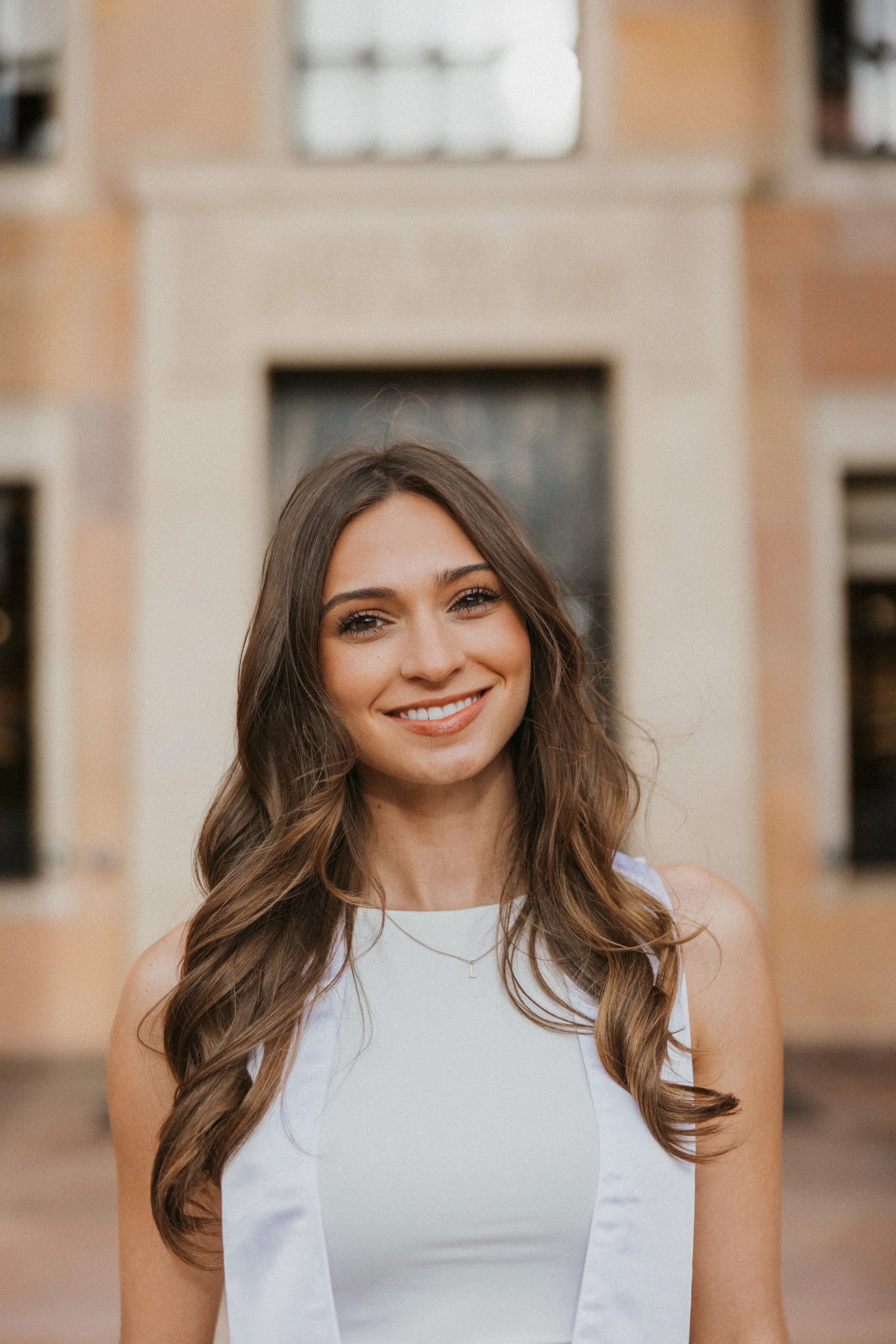 Graduate smiling in front of Norlin Library at CU Boulder