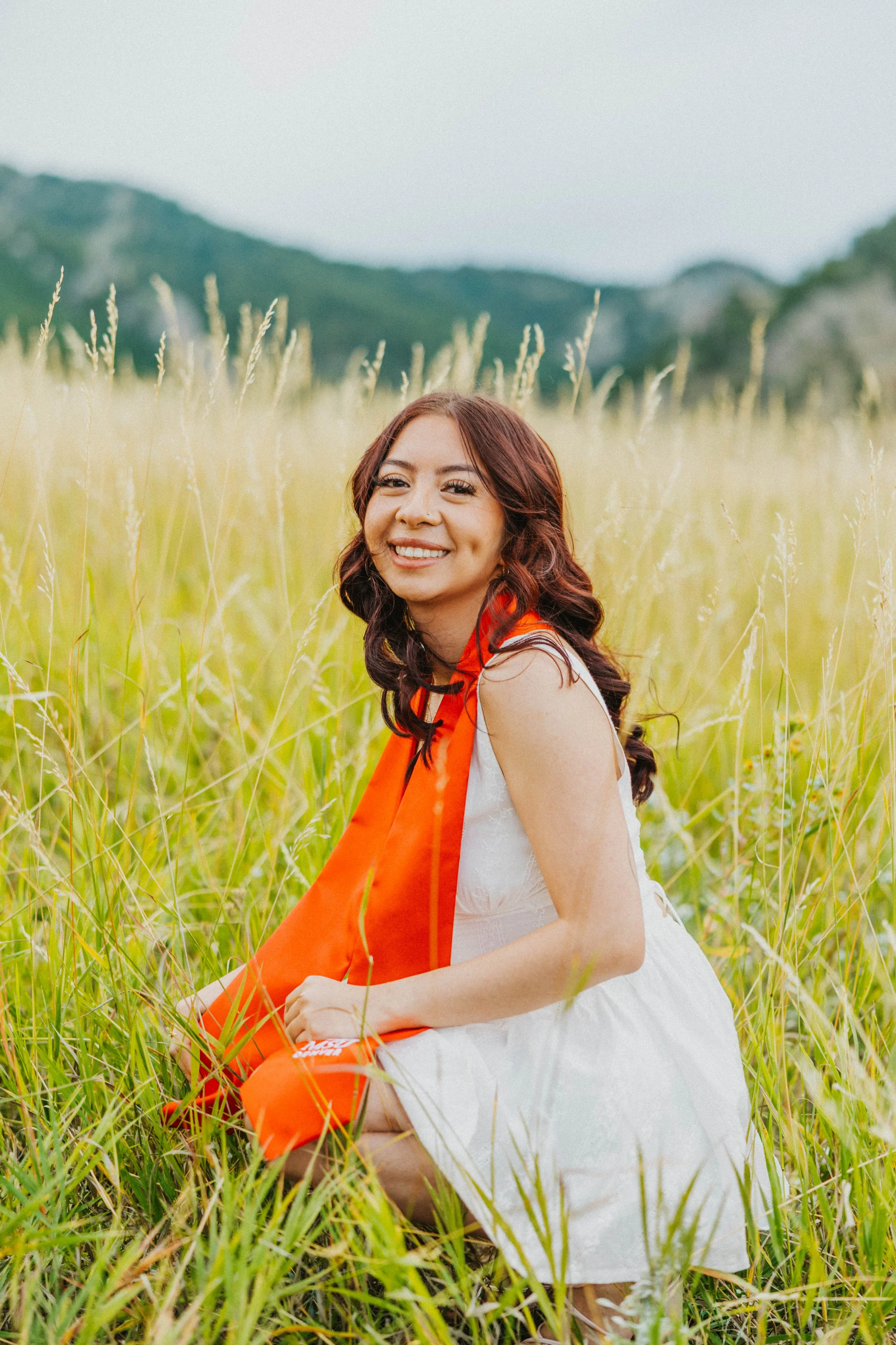 Graduate sitting in grass at Chautauqua Park, Colorado