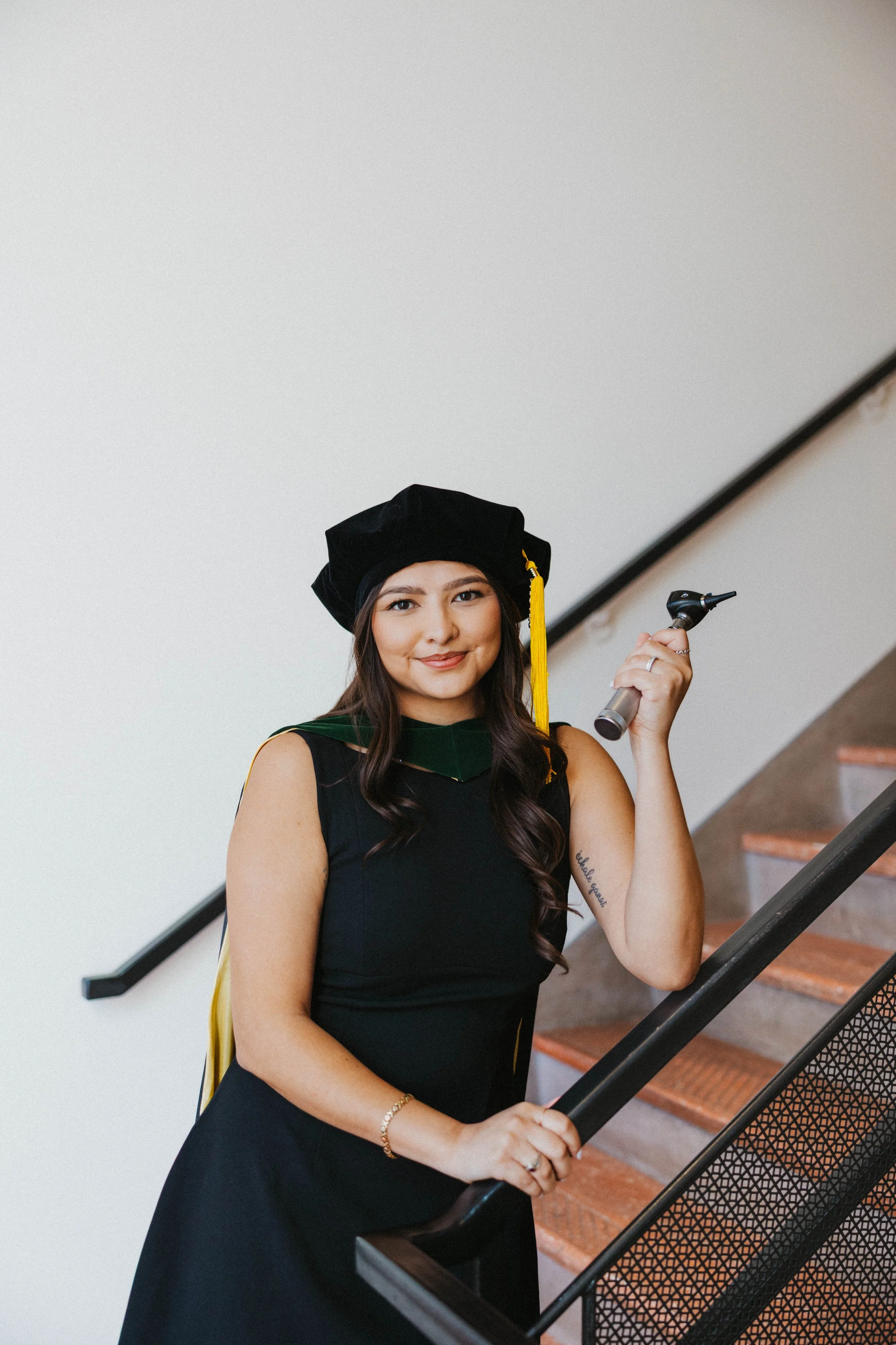 Student holding out object by stairs