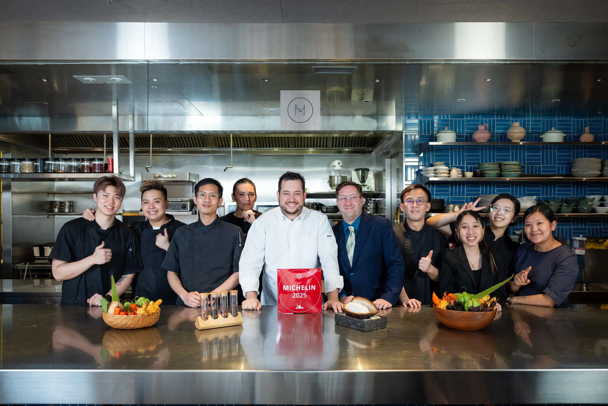 MONO's entire team proudly holding their 2025 Michelin star plaque in the restaurant