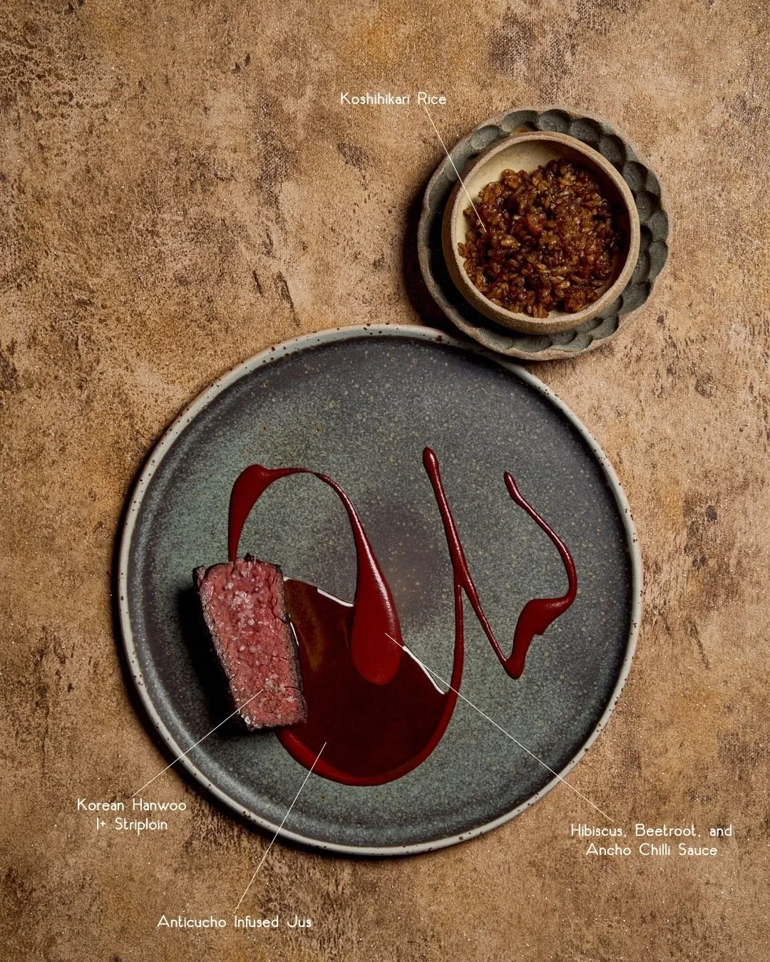 Our charcoal-grilled Korean Hanwoo 1+ Striploin is elevated by a seasonal interpretation, accompanied by hibiscus, beetroot, and ancho chilli sauce. Served with Caribbean-style Koshihikari rice&mdash;slow-cooked in coconut milk and smoked with banana